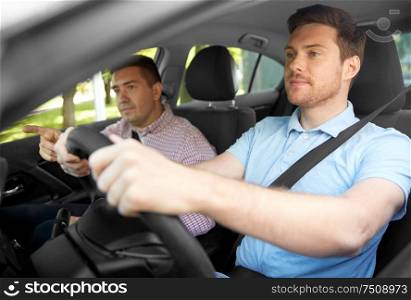 driver courses and people concept - car driving school instructor teaching young man to drive. car driving school instructor teaching male driver