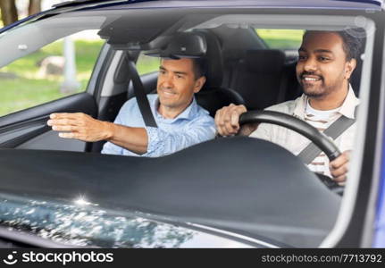 driver courses and people concept - car driving school instructor teaching young man to drive. car driving school instructor teaching male driver