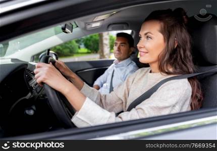 driver courses and people concept - car driving school instructor teaching young woman to drive. car driving school instructor teaching woman