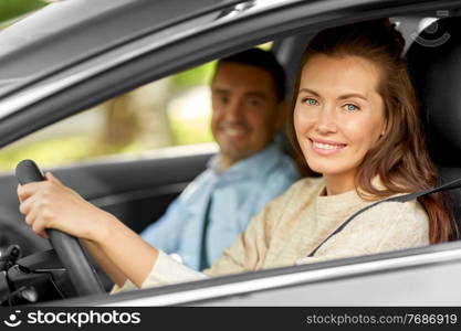 driver courses and people concept - car driving school instructor teaching young woman to drive. car driving school instructor teaching woman