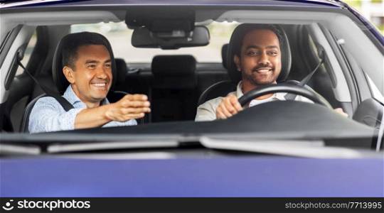 driver courses and people concept - happy smiling car driving school instructor teaching young man to drive. car driving school instructor teaching male driver