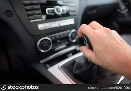 Driver shifting the gear stick inside of car