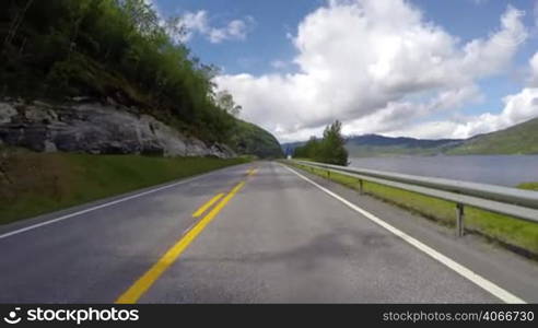 Driving a Car on a Mountain road in Norway with high snow wall