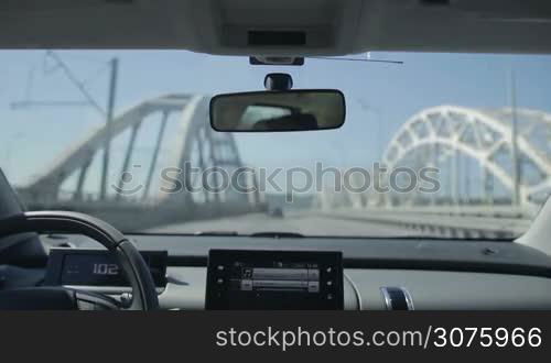 Driving car on the bridge in the city. View inside out