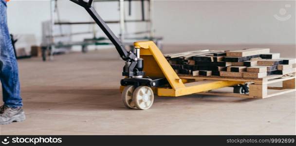 Driving construction material with hand pallet truck