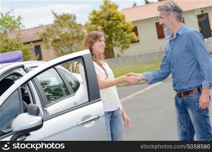 Driving instructor and student shaking hands