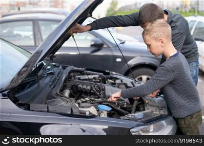Driving instructor, car breakdown, repair cars, spare parts, technical condition, driving school, teach a child, father and son, long trip, hold the steering wheel, car device, family day, open hood. Dad shows his little happy son how the car works