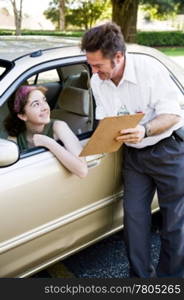 Driving instructor showing a teen driver the results of her test.