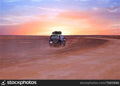 Driving through the Sahara desert in Morocco at sunset