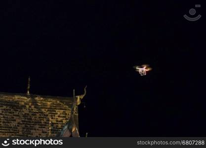 drone flying at ancient buddhist church temple for aerial night photography
