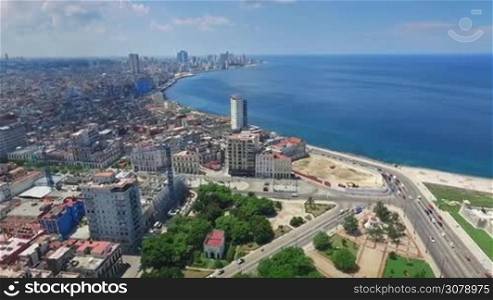 Drone flying over Havana, Cuba: Caribbean sea and Malecon promenade. Aerial view of La Habana skyline, Cuban capital city. Urban landscape seen from the sky with old buildings and ocean.
