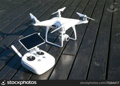 drone quad copter with high resolution digital camera and its remote control pad with smartphone on grass