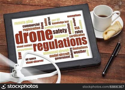 drone regulations (USA related) word cloud on a digital tablet with a cup of coffee and rotating propeller