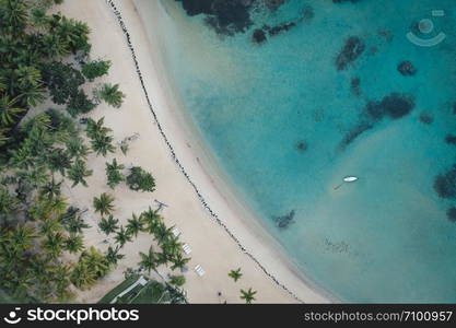 Drone shot of tropical beach with white boat anchored.Samana peninsula,Bahia Principe beach,Dominican Republic.