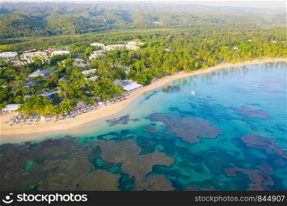 Drone shot of tropical beach with white boat anchored.Samana peninsula,Bahia Principe beach,Dominican Republic.