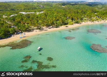 Drone shot of tropical beach with white boat anchored.Samana peninsula,Bahia Principe beach,Dominican Republic.