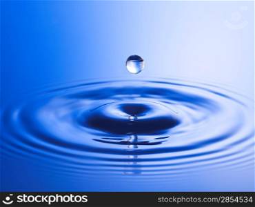 Drop hitting surface of water close-up