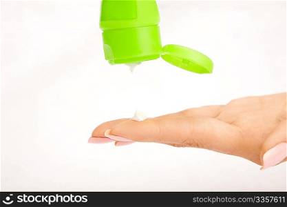 Drop of a cream from a tube on the hand finger, isolated