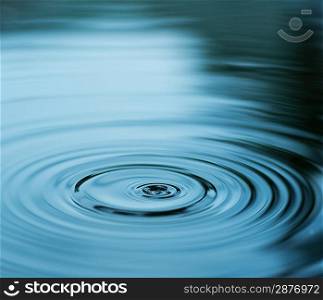 Droplet falling in blue water