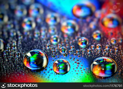 Droplets of water in a vivid colorful blurry background. Droplets in abstract colors.