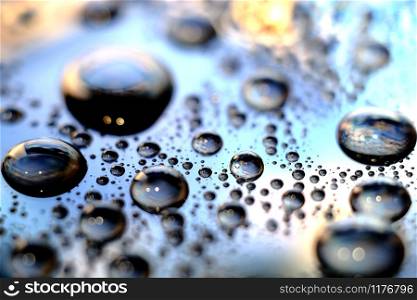Droplets of water in a vivid colorful blurry background. Droplets in abstract colors.