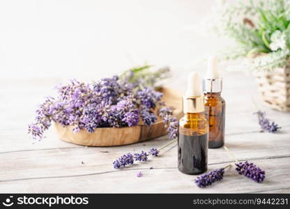 Dropper bottles with lavender cosmetic oil or face serum with fresh lavender flowers on white wooden rustic board. Herbal cosmetics and modern apothecary concept. Lavender beauty products. Lavender beauty products