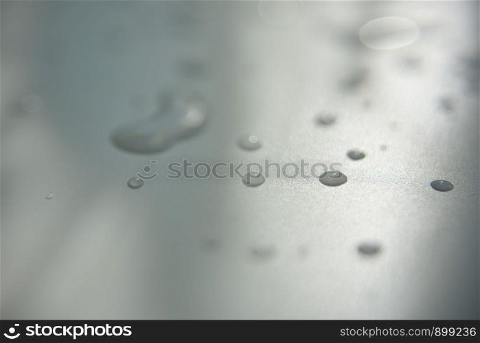 drops of clear water on white surface with abstract shadow