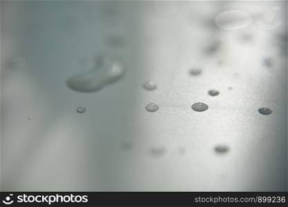 drops of clear water on white surface with abstract shadow