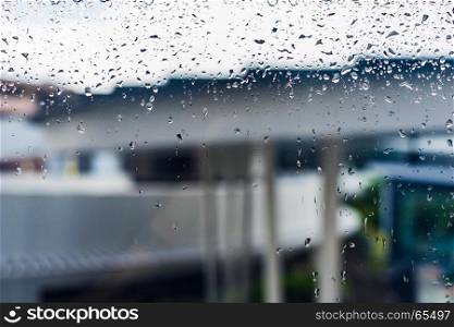 Drops of rain on a window glass, Through the window view of overcast building, drops on glass, window condensation