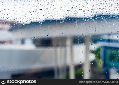 Drops of rain on a window glass, Through the window view of overcast building, drops on glass, window condensation