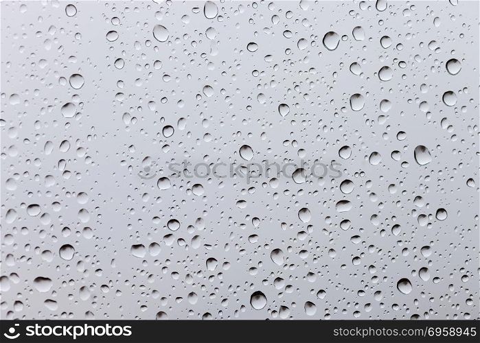 Drops of rain on a window glass. Through the window view of overcast clouds