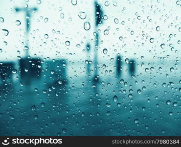 Drops of rain on glass window with blue toned color&#xD;