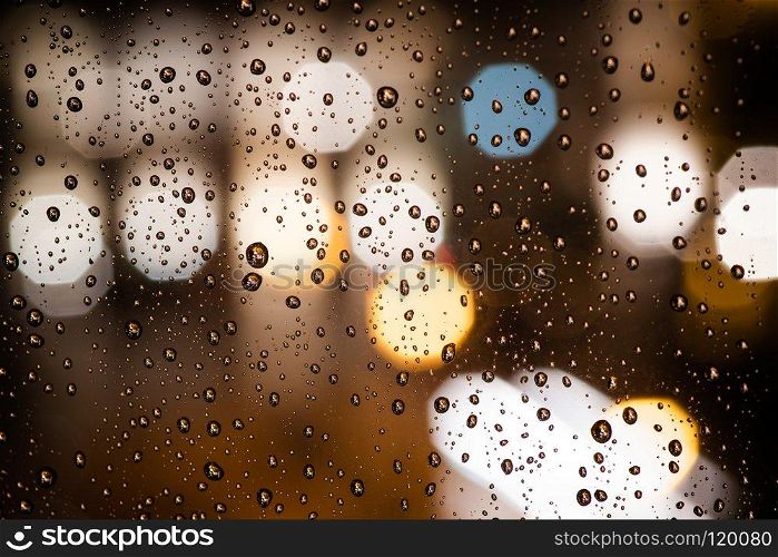 Drops of rain on window with abstract bokeh city lights. Drops of rain on window with abstract lights