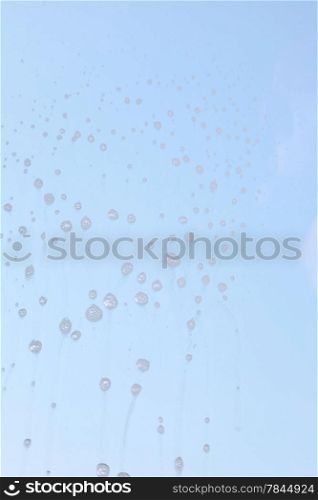 Drops on the windowpane, cleaning window with spray detergent. Glass cleaner on pane.