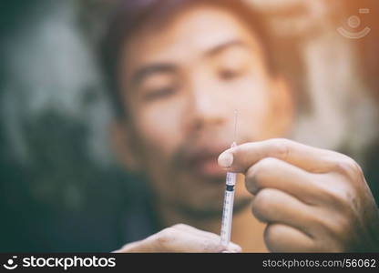 Drug addiction, male using drugs in syringe