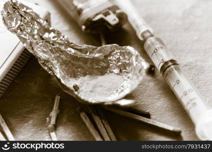 Drug syringe and cooked heroin on spoon