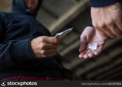 drug trafficking, crime, addiction and sale concept - close up of addict with money buying dose from dealer on street