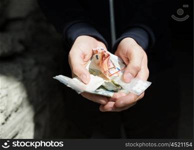 drug trafficking, crime, addiction and sale concept - close up of addict hands with drugs and money