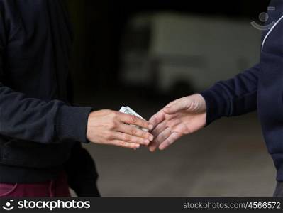 drug trafficking, crime, addiction and sale concept - close up of addict paying money to drug dealer on street