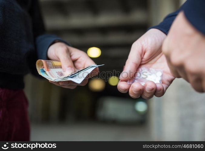 drug trafficking, crime, addiction and sale concept - close up of addict with money buying dose from dealer on street