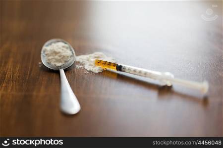 drug use, crime, addiction and substance abuse concept - close up of spoon and syringe with crack cocaine drug dose
