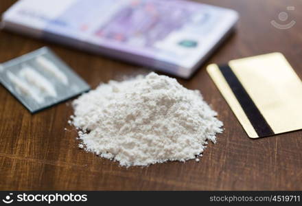 drug use, crime, addiction and substance abuse concept - close up of crack cocaine drug dose track on mirror with credit card and money