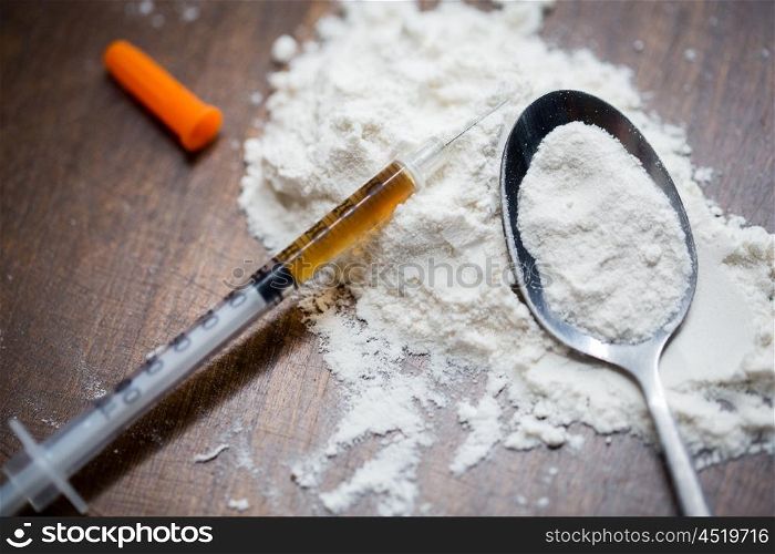 drug use, crime, addiction and substance abuse concept - close up of spoon and syringe with crack cocaine drug dose