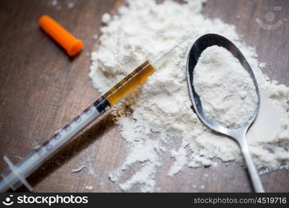 drug use, crime, addiction and substance abuse concept - close up of spoon and syringe with crack cocaine drug dose