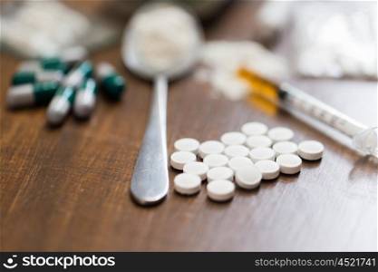 drug use, crime, addiction and substance abuse concept - close up of drugs with money, spoon and syringe