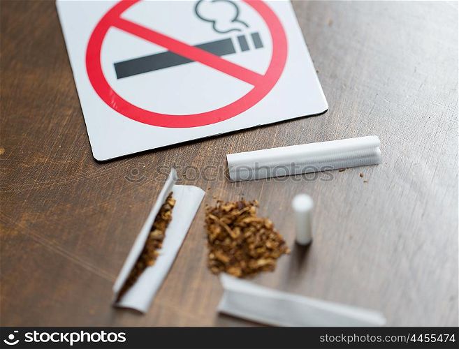drug use, substance abuse, addiction and no smoking concept - close up of marijuana or handmade cigarette with prohibiting sign