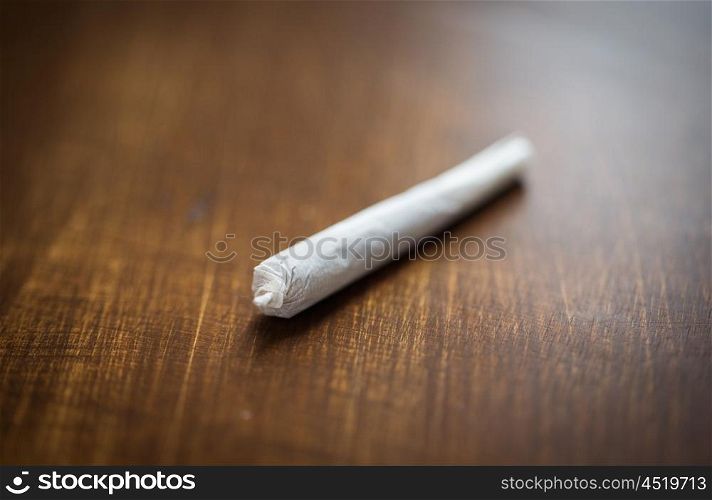 drug use, substance abuse, addiction and smoking concept - close up of marijuana joint or handmade cigarette