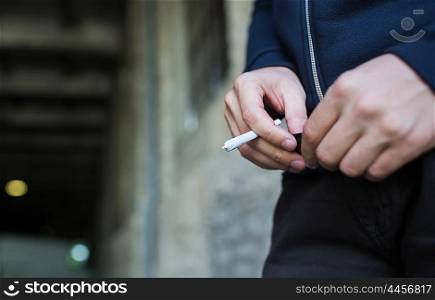 drug use, substance abuse, addiction, people and smoking concept - close up of addict hands with marijuana joint and lighter