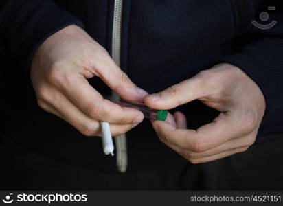 drug use, substance abuse, addiction, people and smoking concept - close up of addict hands with marijuana joint and blunt tube