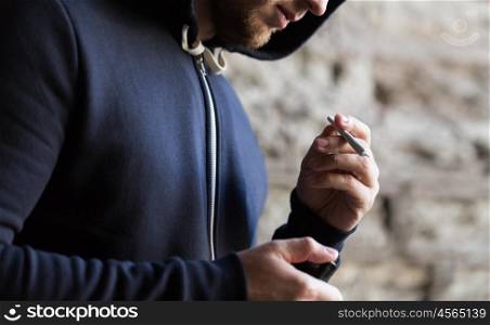 drug use, substance abuse, addiction, people and smoking concept - close up of addict with marijuana joint and lighter